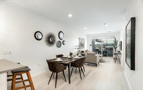 A modern dining room with a table set for four.