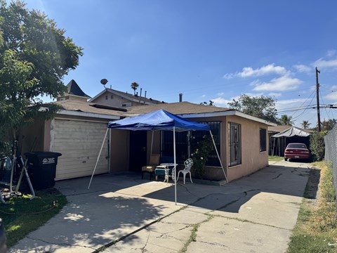 A house with a blue tarp covering a patio area.