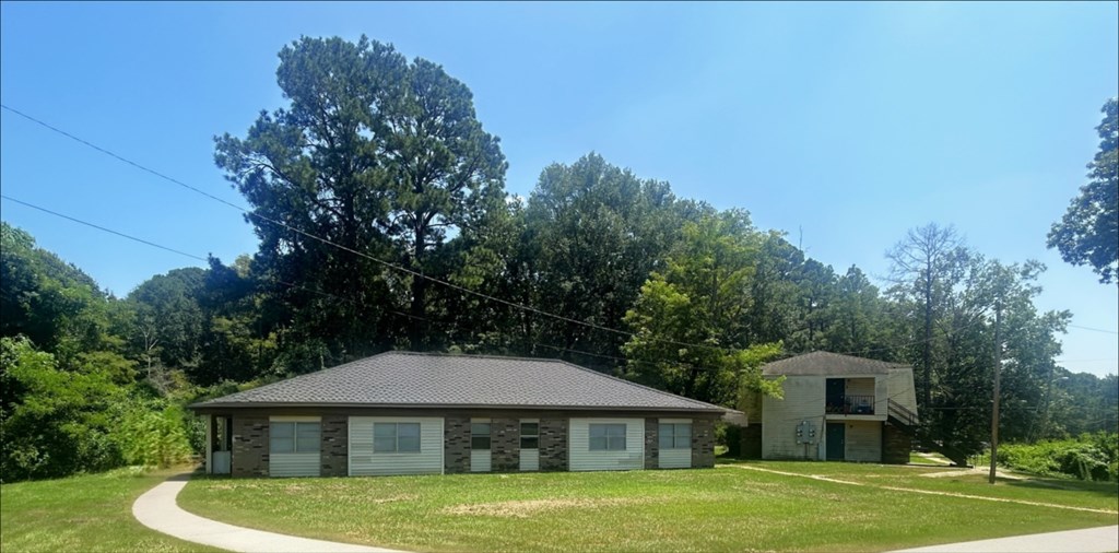 A house with a grey roof is surrounded by greenery.