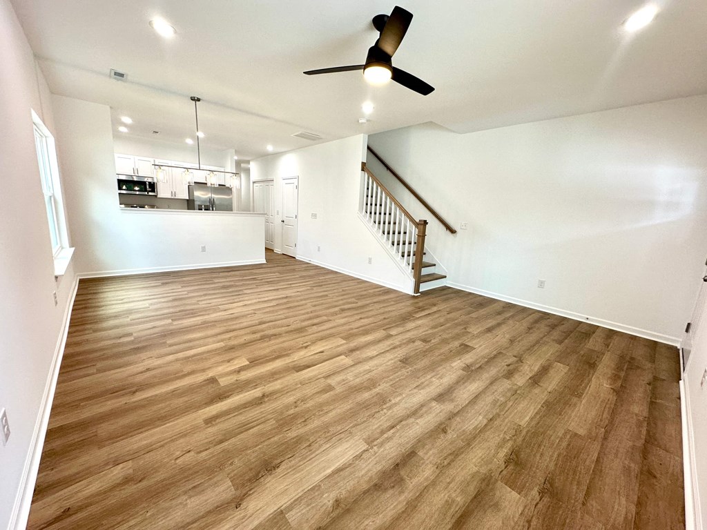 A room with wooden flooring and a ceiling fan.