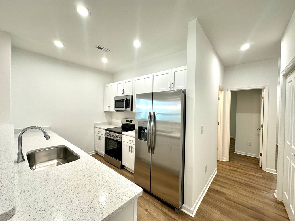 A modern kitchen with a stainless steel refrigerator and a granite countertop.