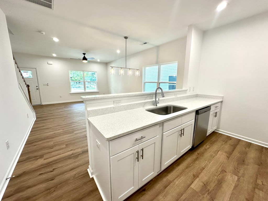 A kitchen with white cabinets and a sink.