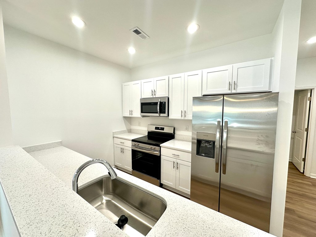 A kitchen with white cabinets and stainless steel appliances.
