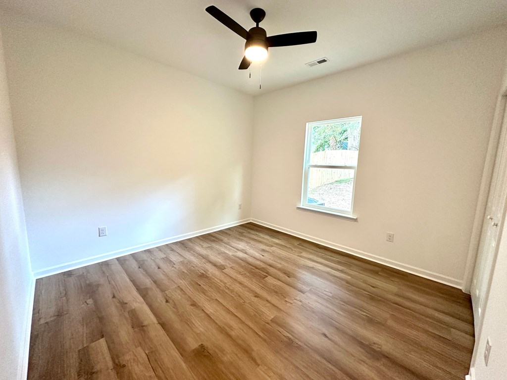 A room with a ceiling fan and a window.