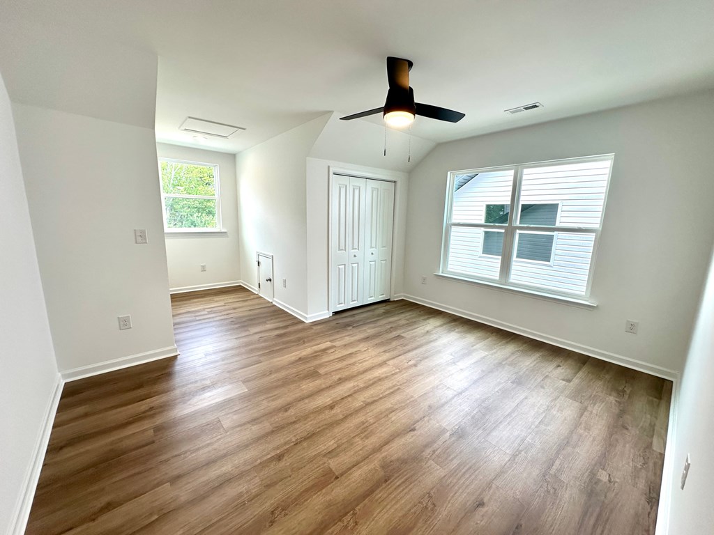 A room with wooden flooring and a ceiling fan.