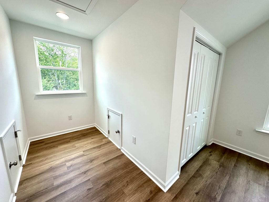 A room with a window and wooden floors.