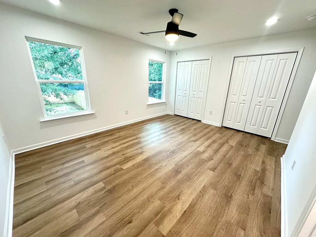 A room with wooden flooring and white walls.