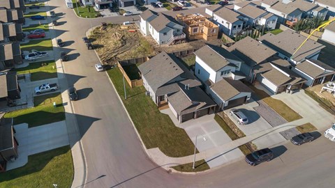 A residential area with houses and cars.