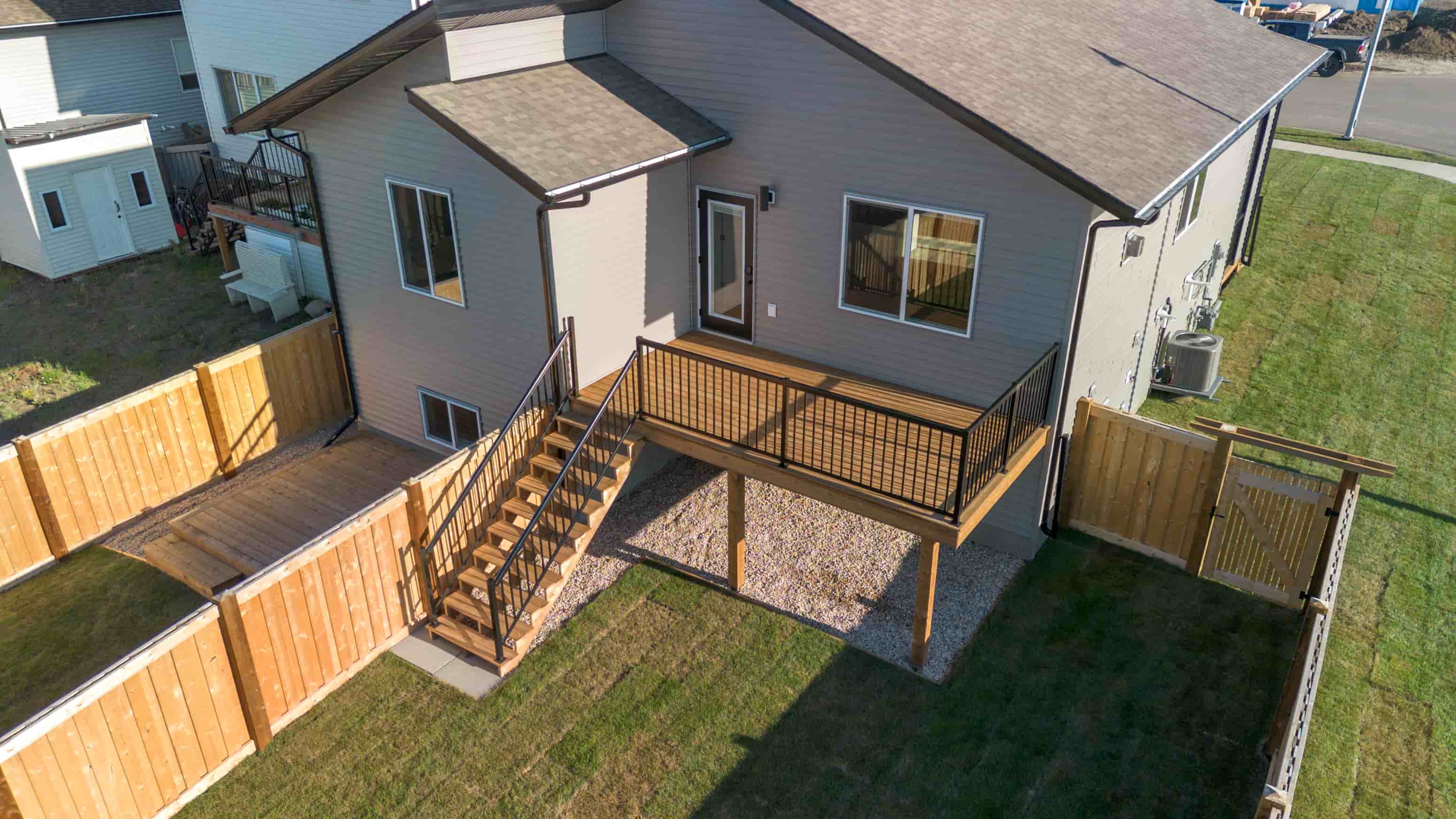 A house with a deck and a brown fence.