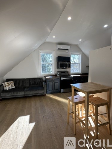 A living room with a couch, a table, and a window.