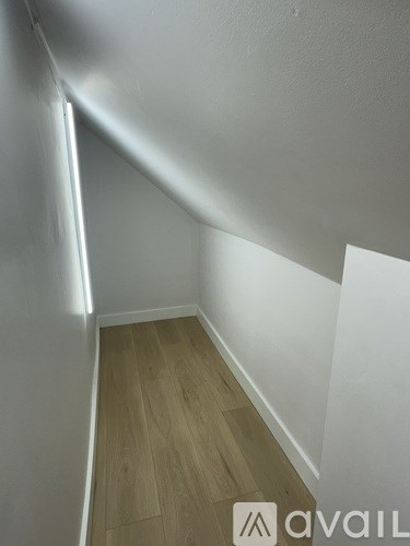 A room with wooden flooring and white walls.