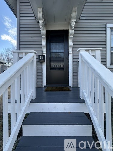 A house numbered 311 has a white railing and steps leading to the front door.