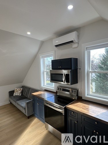 A kitchen with a stove top oven and a couch.