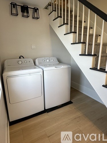 Two white front loading washing machines in a laundry room.