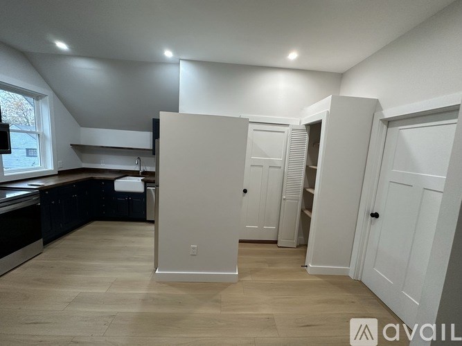 A kitchen with a window, sink, and cabinets with a countertop.