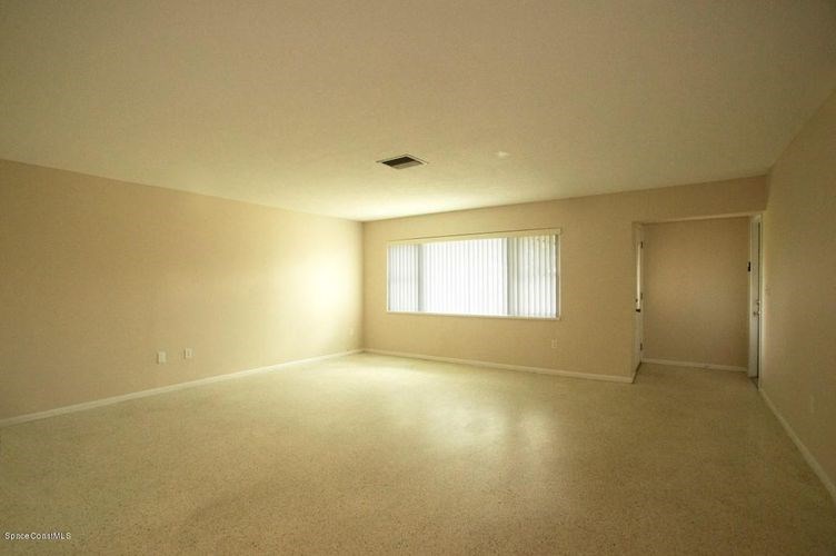 A large empty room with a window on the wall.