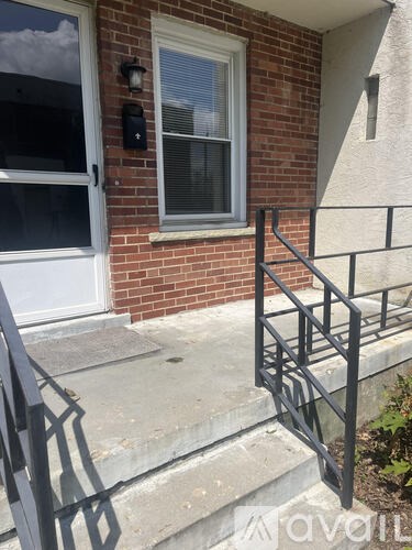 A red brick house with a window and a mailbox.