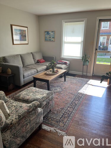 A living room with a grey couch, a coffee table, and a rug.