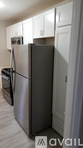 A stainless steel refrigerator stands in a kitchen.