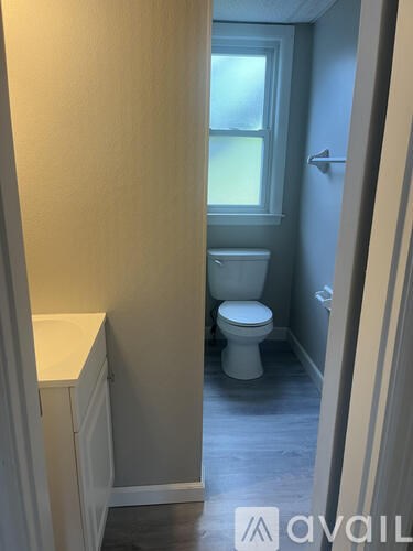 A bathroom with a toilet and a window.