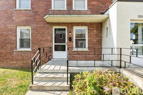 A brick house with a white door and windows.