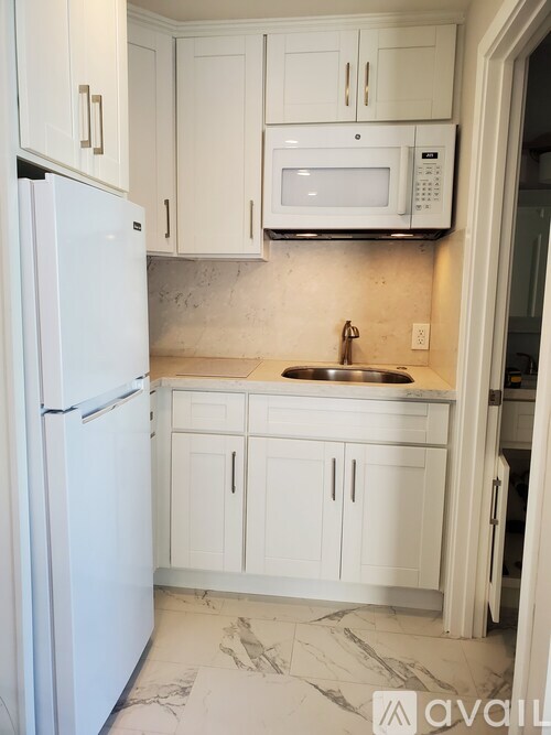 A kitchen with white appliances and cabinets.