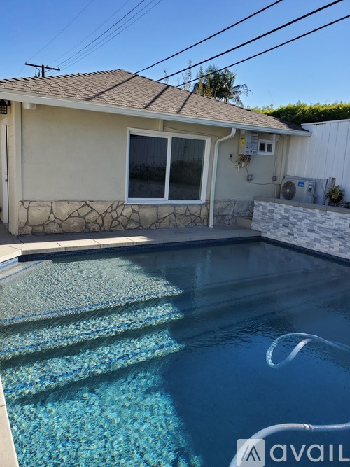 A house with a pool in front of it.