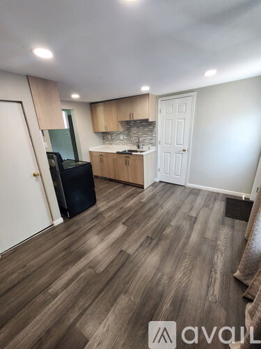A kitchen with wooden floors and a white door.
