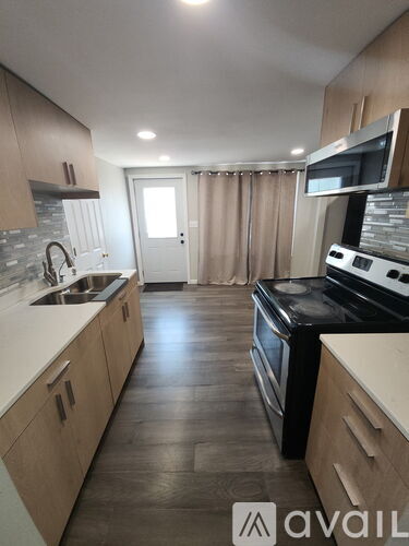 A kitchen with wooden cabinets and a black stove top oven.