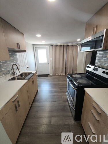 A kitchen with wooden cabinets and a black stove top oven.