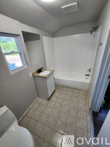 A small bathroom with a toilet, sink, and bathtub.