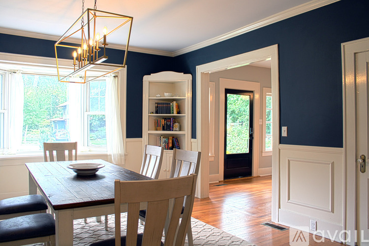 A dining room with a wooden table and chairs.