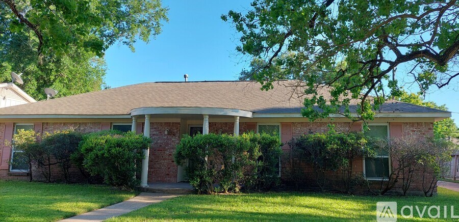 A house with a front yard and a tree in front.