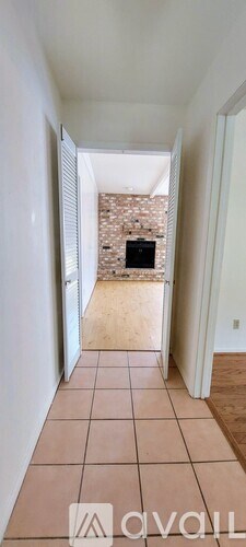 A hallway with tiled flooring and a stone wall in the background.