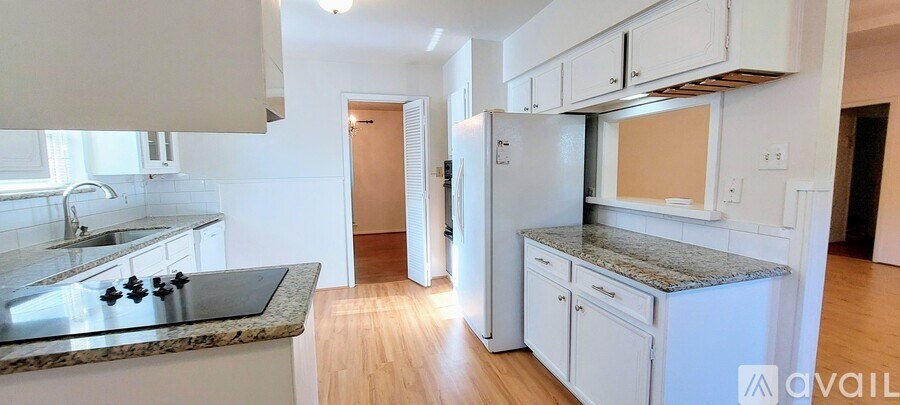 A kitchen with white cabinets and a granite counter top.
