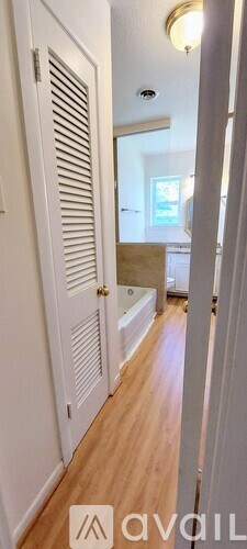 A hallway with white doors and wooden floors.