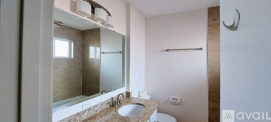A bathroom with a sink, mirror, and toilet.