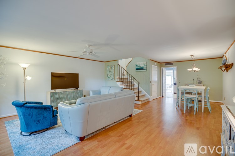 A living room with a blue chair and a white couch.