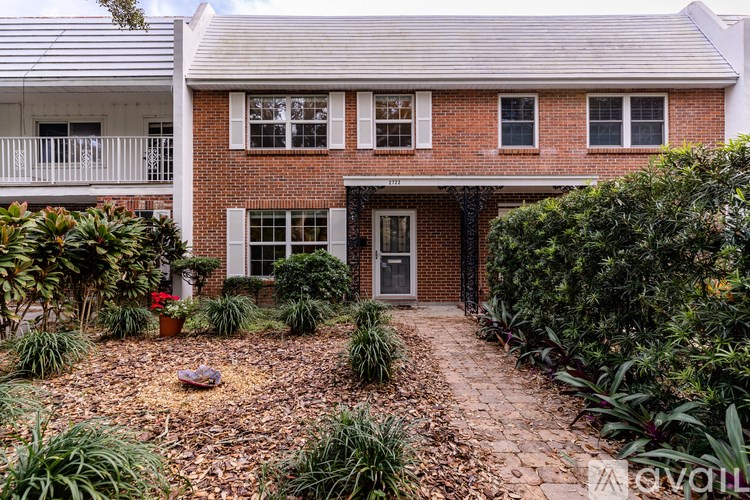 A brick house with a garden in front.