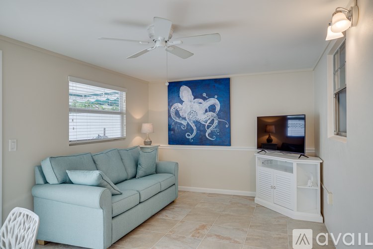 A living room with a blue couch and a ceiling fan.
