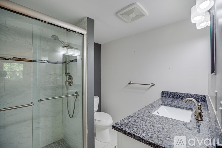 A bathroom with a marble countertop and a walk-in shower.