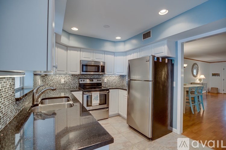 A modern kitchen with stainless steel appliances and a marble countertop.