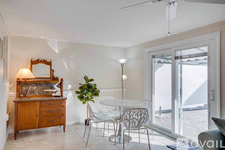 A room with a table, chairs, and a dresser with a mirror.