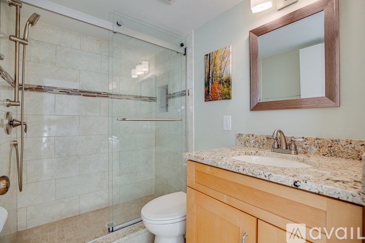A bathroom with a toilet, sink, and shower.
