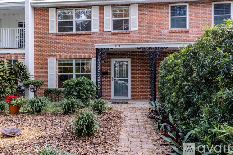A brick house with a grey door and windows.