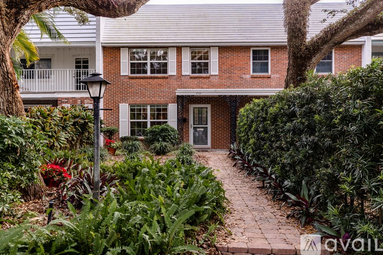 A house with a brick facade and a garden in front.