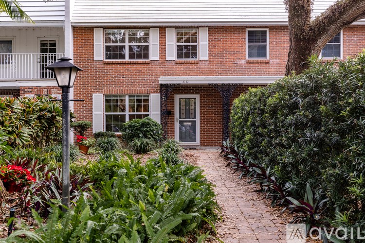 A red brick house with a black door and windows.