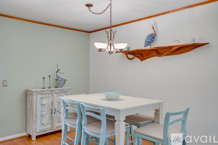 A dining room with a white table and blue chairs.
