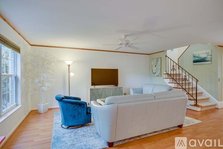 A living room with a blue chair and a white couch.