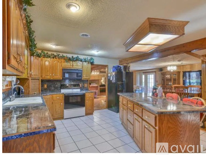 A kitchen with wooden cabinets and a marble countertop.